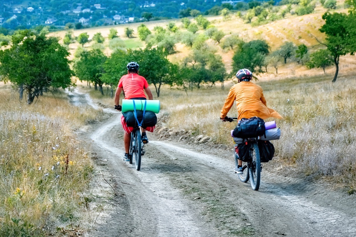 Cyklisti na poľnej ceste nad dedinou — cykloturistika v okolí obce